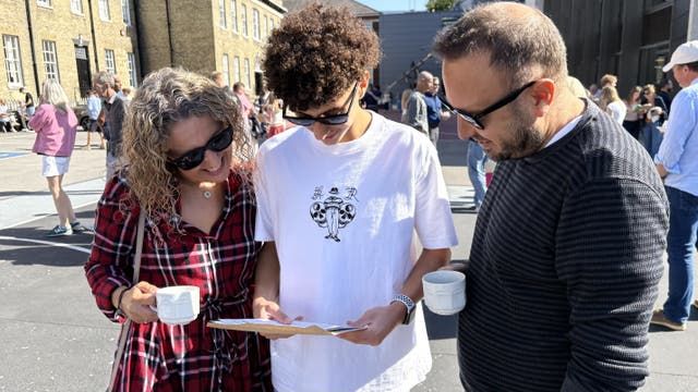 Tuna Lokman looks at his GCSE results with his parents Banu and Utkuat Lokman