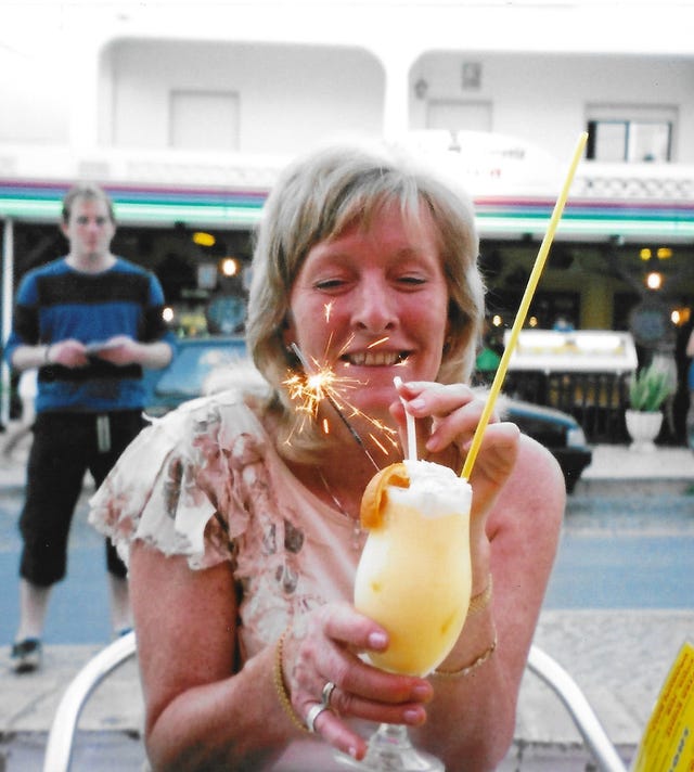 Anette Smith smiling and holding a drink