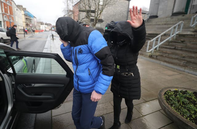 Patrick O'Brien (left) covers up as he leaves Tralee District Court where he escaped a criminal conviction (Niall Carson/PA)