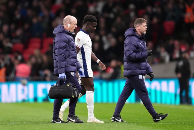 Bukayo Saka limps off the pitch alongside a physio at Wembley