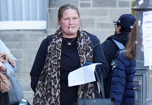 Simone Ramage walking outside, with a cigarette in her mouth