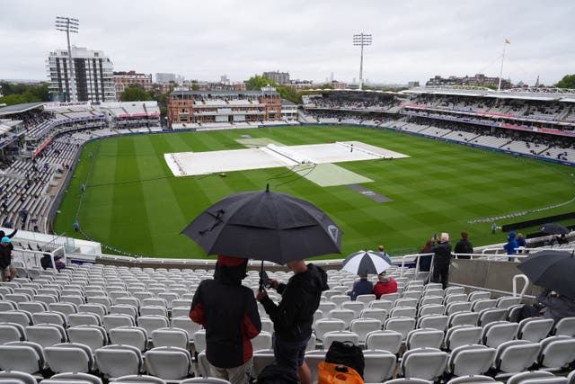 Covers are on, as people shelter under a umbrella from rain