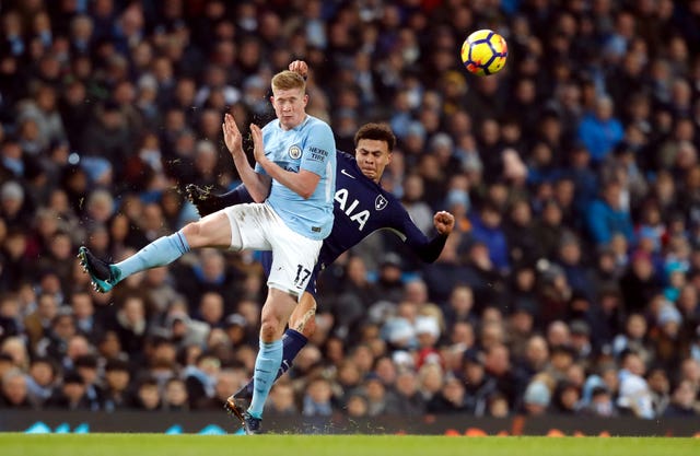 Dele Alli, right, challenges Kevin De Bruyne