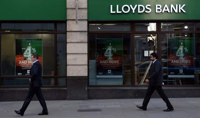Two men walking past a Lloyds branch