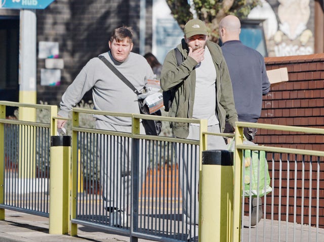 Two men holding belongings as they leave prison