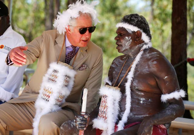 Charles wears a mulka string, a feather stringed headband, as he takes part in a traditional welcome ceremony during a visit to Mount Nhulun in 2018