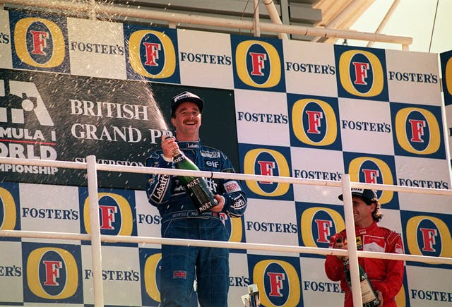 British F1 driver Nigel Mansell celebrates on the podium after his win at Silverstone in 1992