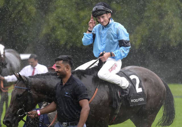 Tom Marquand celebrates after winning the Gordon Stakes