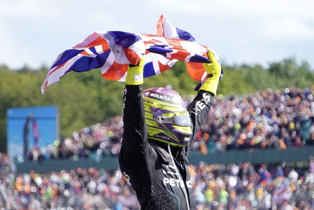 Lewis Hamilton lifts the Union Flag after winning the British GP