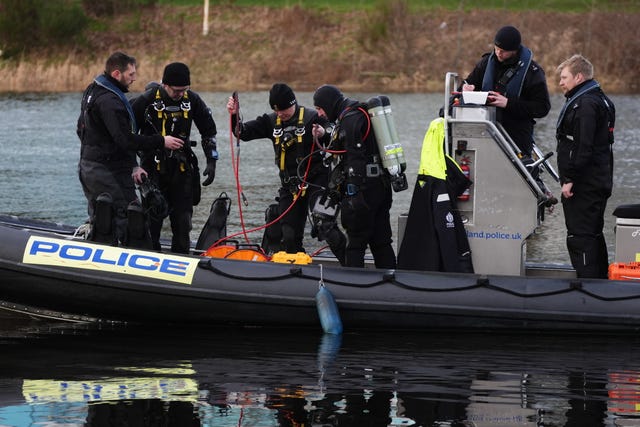 Police divers on inflatable boat on river Dee