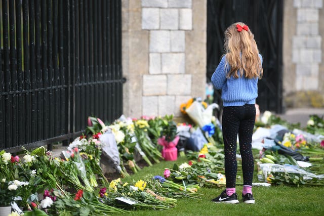 A young girl looks at flowers at Cambridge Gate at Windsor Castle