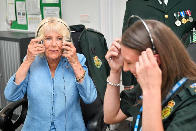 The Duchess of Cornwall (left) removes a headset after listening into an emergency call (Ben Birchall/PA)