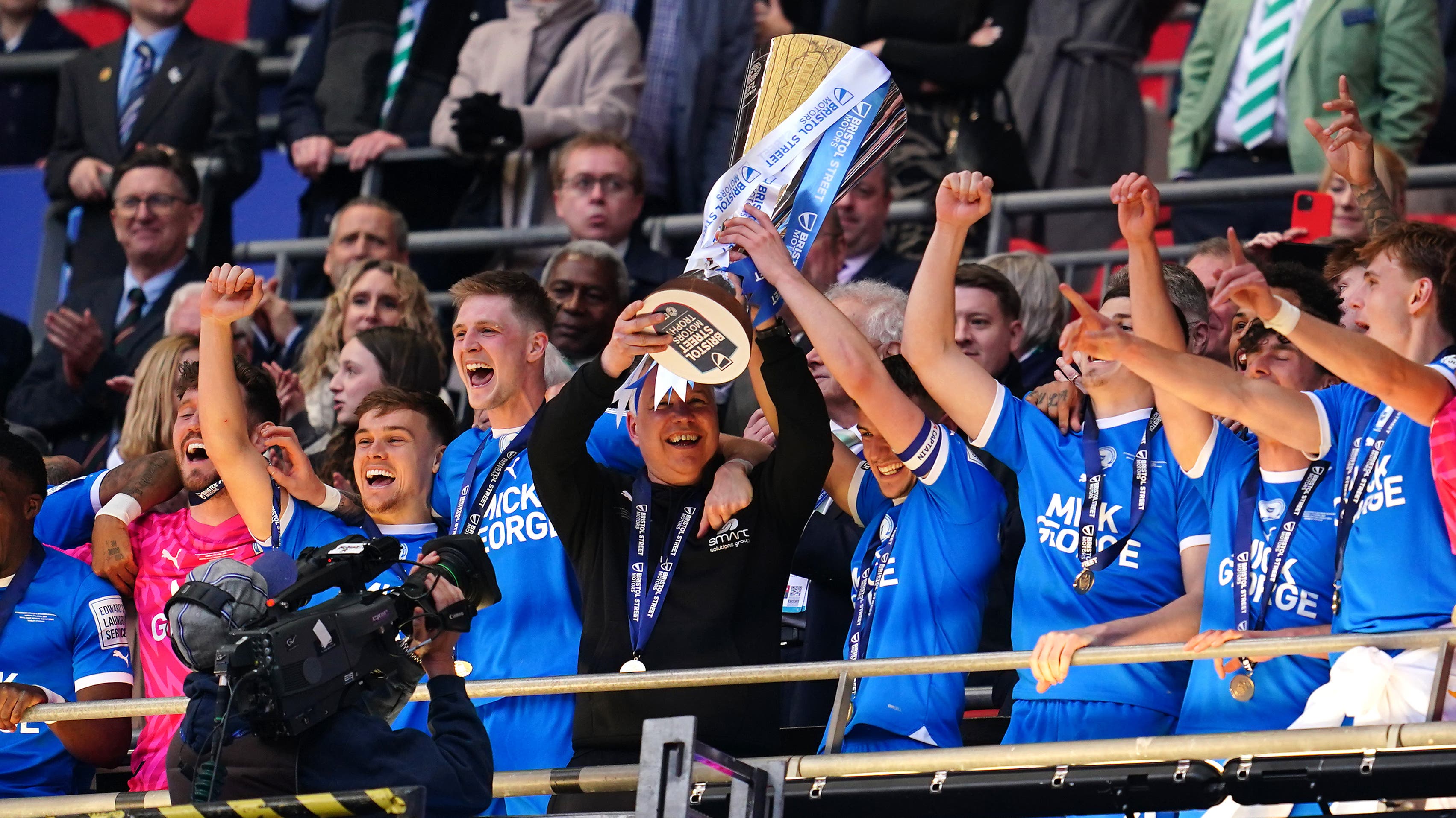 Harrison Burrows and manager Darren Ferguson lift the EFL Trophy (Adam Davy/PA)