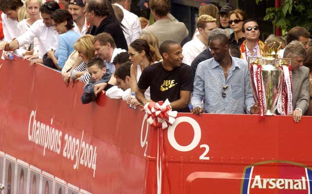 Thierry Henry, Patrick Vieira and Arsene Wenger, front l-r, display the Premier League trophy on Arsenal's 2004 celebratory parade