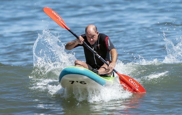 A man enjoys the warm weather on Scarborough beach, North Yorkshire 