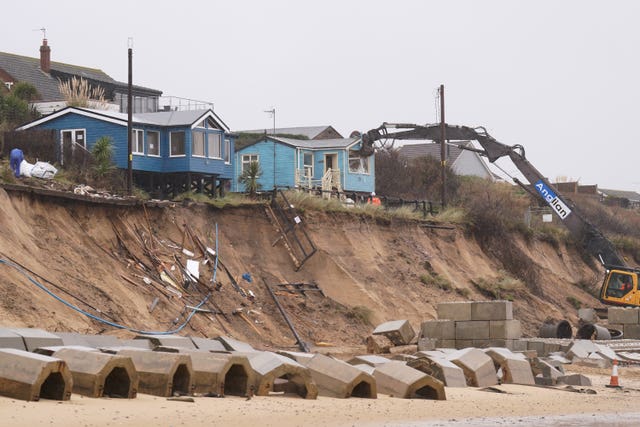Demolition workers tear down the second of five clifftop homes in the village of Hemsby which has been hit by coastal erosion. 