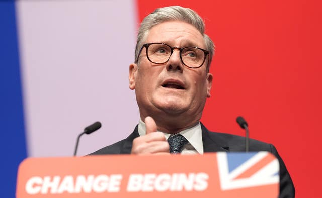 Prime Minister Sir Keir Starmer stands at a podium with a Union Jack display behind him delivering a speech 