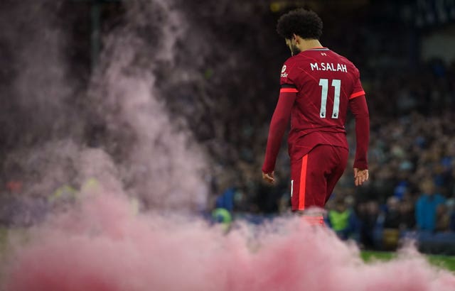 Liverpool forward Mohamed Salah walks through red smoke