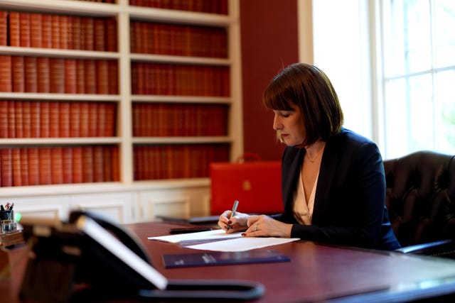 Rachel Reeves works at her desk in the Treasury, with her red box in the background