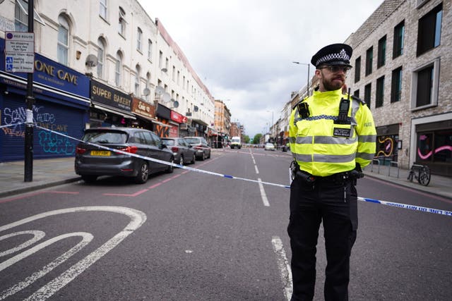 Police officer at the scene of a shooting at Kingsland High Street, Hackney, east London.