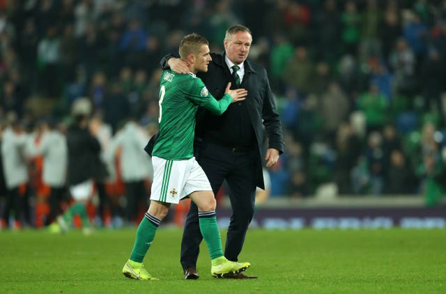 Steven Davis, who missed a penalty, and manager Michael O’Neill, who is stepping down to join Stoke, embrace after Northern Ireland's draw with Holland