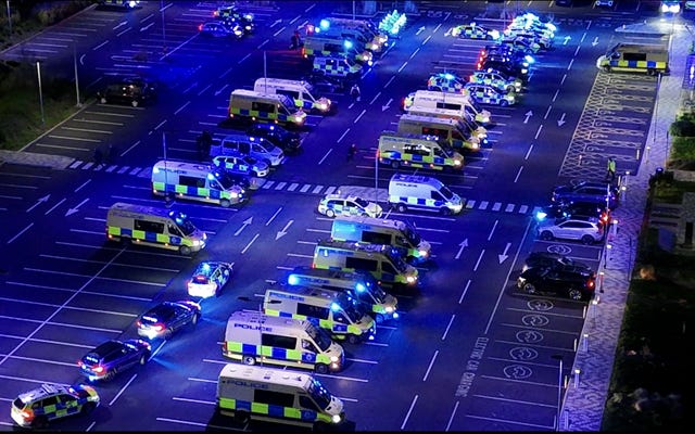 Police vehicles prepare to leave Merseyside Police HQ in Liverpool 