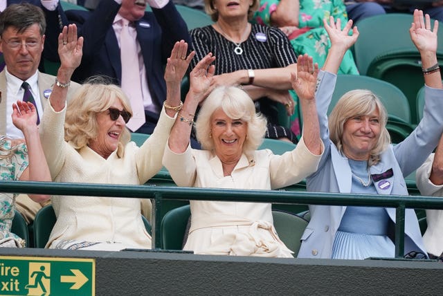 The Queen, her sister Annabel Elliot and Debbie Jevans, chair of the All England Lawn Tennis Club, take part in a wave at Wimbledon