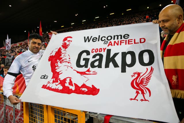 Liverpool supporters hold a welcome sign for new signing Cody Gakpo
