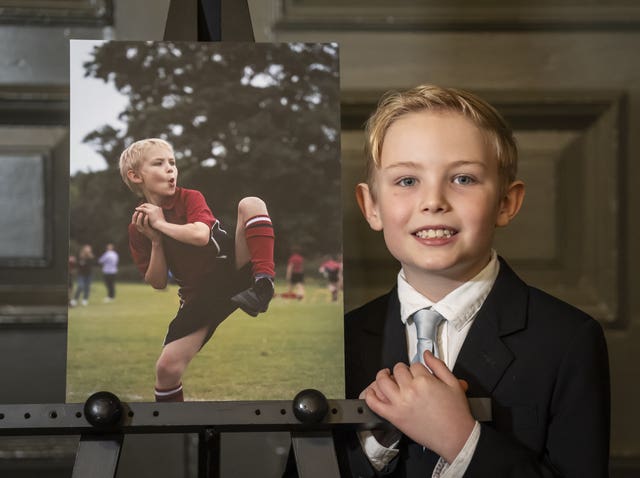 Mateo Robayna with a photograph of himself playing sports taken by his sister