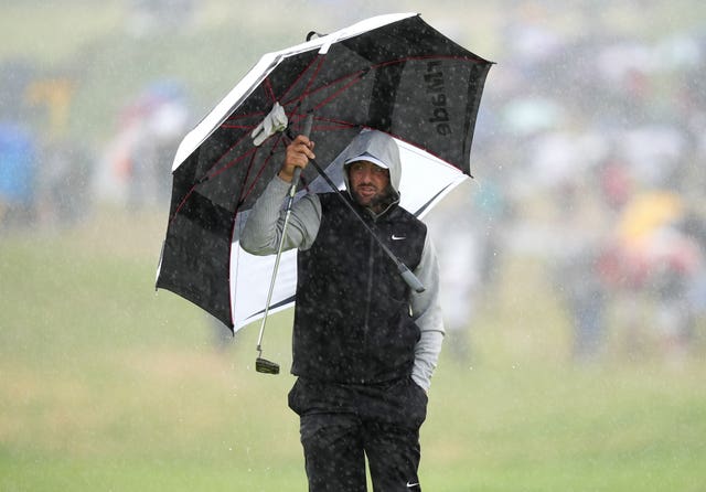  Scottie Scheffler shelters from the rain under an umbrella during day two of The 153rd Open Championship at Royal Portrush