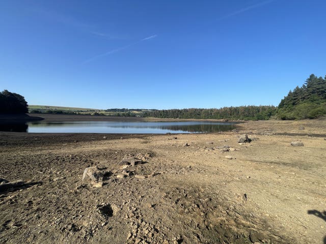 Bare earth and low water levels under a blue sky at a Yorkshire reservoir in July