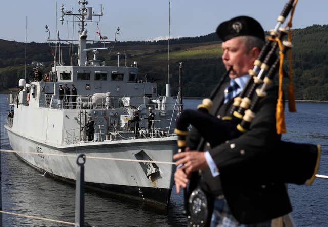 Piper Iain Macpherson plays during a welcome home ceremony as the Royal Navy mine hunter returns to HM Naval Base Clyde