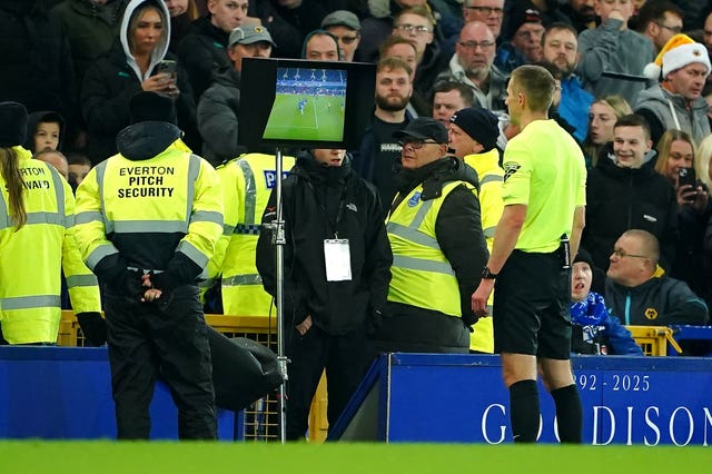 Referee Michael Salisbury views the on pitchside VAR screen during a game at Goodison Park