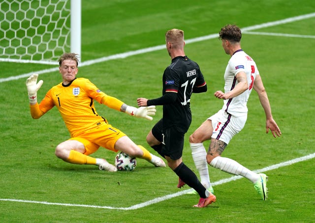 Jordan Pickford, left, saves from Germany's Timo Werner, centre