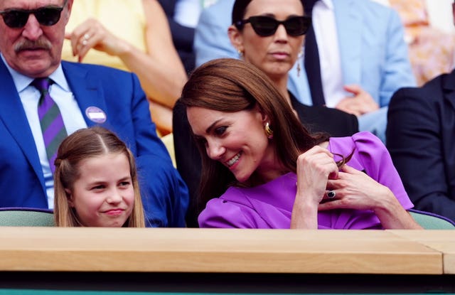 The Princess of Wales leans over to chat with Princess Charlotte in the royal box at Wimbledon 