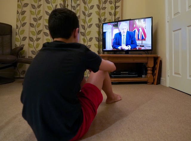 A family member in Nottingham watches Prime Minister Boris Johnson making a televised address to the nation