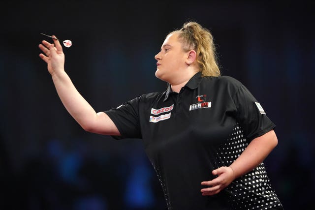 Beau Greaves throws a dart with her right hand