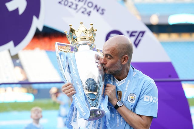 Manchester City manager Pep Guardiola kisses the Premier League trophy