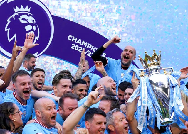 Pep Guardiola, back right, celebrates as Manchester City lift the Premier League trophy. The City boss claimed his club 