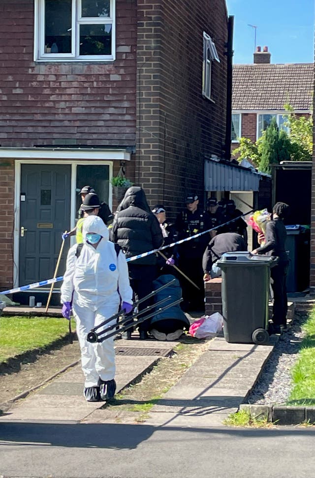 Police officers, including ones wearing forensics suits, at the scene in Lovett Avenue, Oldbury