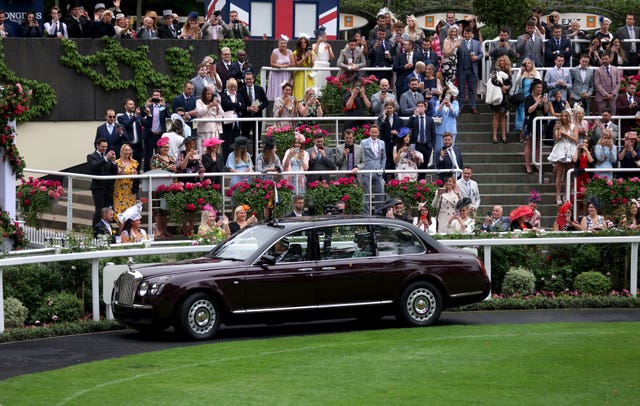Racegoers applaud as the Queen arrives