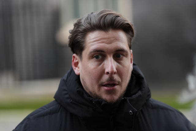 Head and shoulders photo of Joe Bennett outside, wearing a black coat