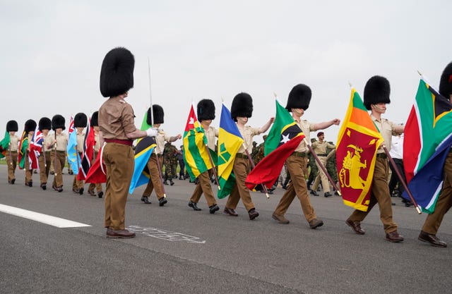 Guards carry flags from Commonwealth countries during a full tri-service and Commonwealth rehearsal at RAF Odiham in Hampshire, ahead of their involvement in the second procession that accompanies King Charles III and Queen Camilla from Westminster Abbey back to Buckingham Palace, following the coronation service on May 6 at the abbey in London 