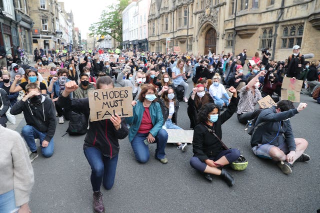 People during a protest calling for the removal of the statue of 19th century imperialist, politician Cecil Rhodes from an Oxford college which has reignited amid anti-racism demonstrations 