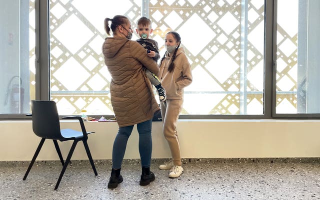 Members of a Ukrainian family wait for paperwork to be completed at the ferry terminal in Calais, France, after they fled Ukraine