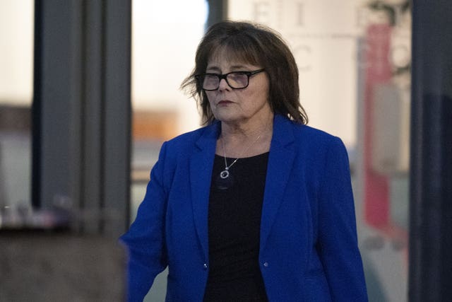 Jeane Freeman in blue blazer, walking outside building