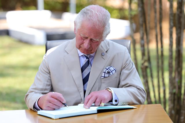 The Prince of Wales signs the visitors' book during his visit to the Nyamata Church Genocide Memorial