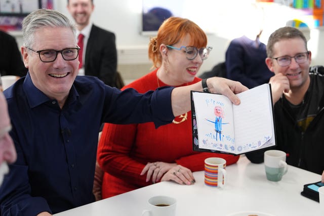 Keir Starmer holds up a picture of himself drawn by a child