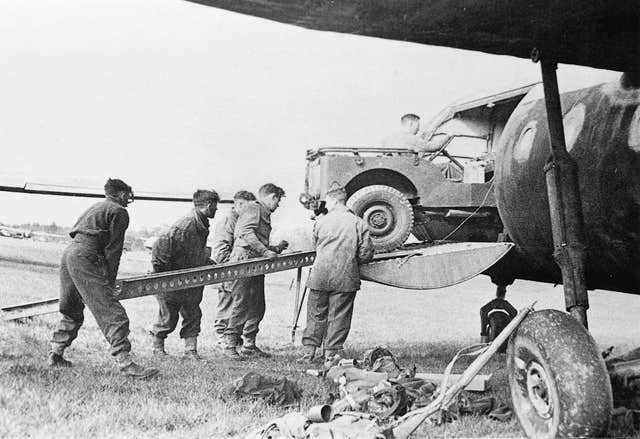 A black and white image of a vehicle being loaded onto a glider 