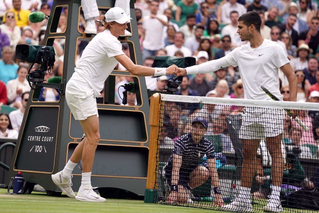 Jannik Sinner, left, and Carlos Alcaraz, right, shake hands at Wimbledon